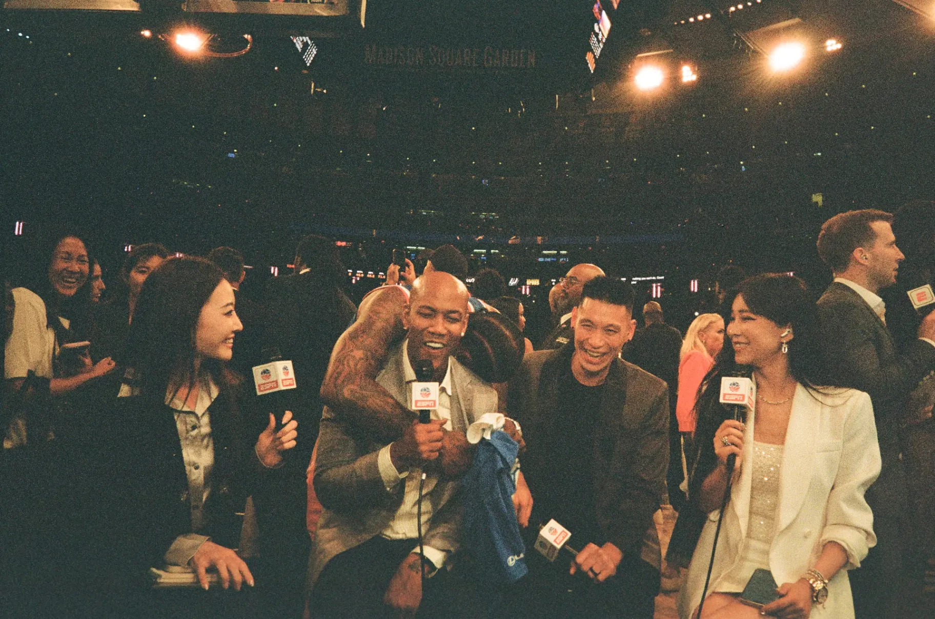 Basketball player hugging a seated man at Madison Square Garden, Knicks Finals